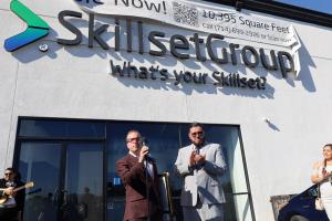 Clint Armstrong, CEO, and Jose Baca, CMO, standing in front of a mic outside of the new SkillsetGroup corporate office after giving remarks at the ribbon cutting ceremony.