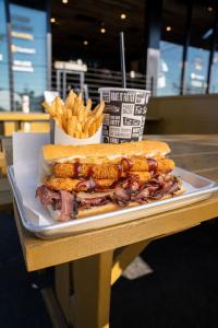 photo of french fries, meaty sandwich, and beverage