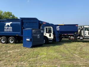 Blue and white trucks with a dumpster in front ready for pickup services