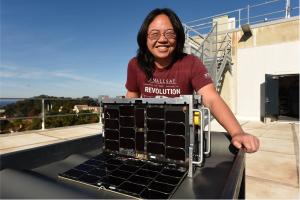 Dr. Wenschel Lan, interim chair of the Naval Postgraduate School, Space Systems Academic Group poses with the Otter CubeSat.