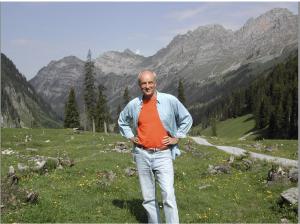 man standing in a valley with great mountains behind him