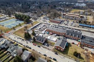 A birds-eye view of Kennett Winterfest showcases three rows of brewery tents, a large heated tent next to several food trucks, and a crowd of people entering the festival in Kennett Square, PA.