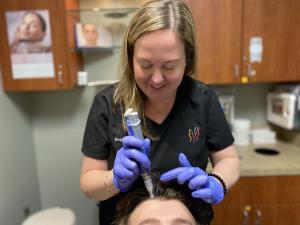 Hope Merz, CNP, DNP with Advanced Cosmetic Surgery & Laser Center applies Exosomes to a patient's scalp to promote hair growth.