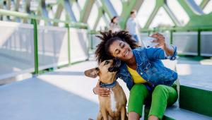 A person poses with a dog to take a selfie.