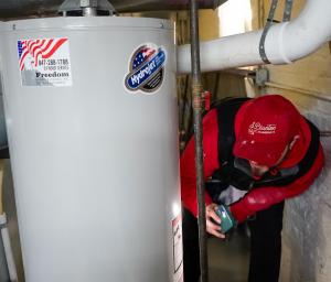 J. Blanton Plumbing technician performing a water heater repair, showcasing the company’s expertise in water heater maintenance, repair, and installation to help homeowners address wear and tear after winter.