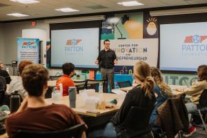 Spencer Patton standing in front of a classroom of students talking