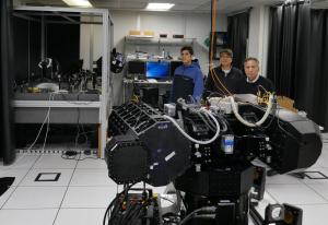 Naval Postgraduate School (NPS) researchers stand to the side of the invisible light pathway between the High Energy Laser Beam Control Research Testbed (HBCRT) and and the range-in-a-box (RIAB).