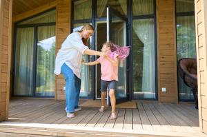 Mom and daughter are having a fun time near a storm door.