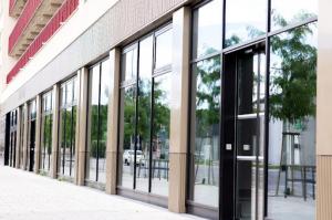 A modern glass facade of a ground-floor commercial building featuring high-quality glass and door installations.