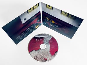 a CD laying in front of a 4-panel digipak of the physical album