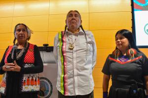 Three judges of the International Rights of Nature Tribunal, from left to right: Casey Camp-Horinek taking the microphone, Tom Goldtooth center, Patricia Gualinga on the right, listening to her words.