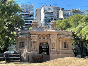 Pupy standing in front of what was once know as the Hindu Temple of the Elephants in her ecoparque enclosure against the backdrop of the city of Buenos Aires