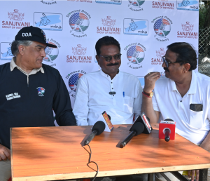 Three men sitting at a table with microphones in front of them are engaged in conversation, set against a backdrop featuring DDA logo. On the left is Mr. Kanwal Sra – Founder, Chairman and CEO of DDA wearing a cap and shirt with DDA written on it. In the 