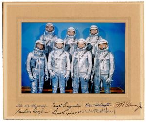 Vintage color photograph of all of the Mercury 7 astronauts in silver space suits and helmets, signed by: M. Scott Carpenter; L. Gordon Cooper, Jr.; John H. Glenn, Jr.; Virgil I. Grissom; Walter M. Schirra, Jr.; Alan B. Shepard, Jr.; and Donald K. Slayton