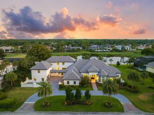 Front exterior of 6536 Highcroft Drive, a luxury estate in Quail West with modern architecture and lush landscaping.