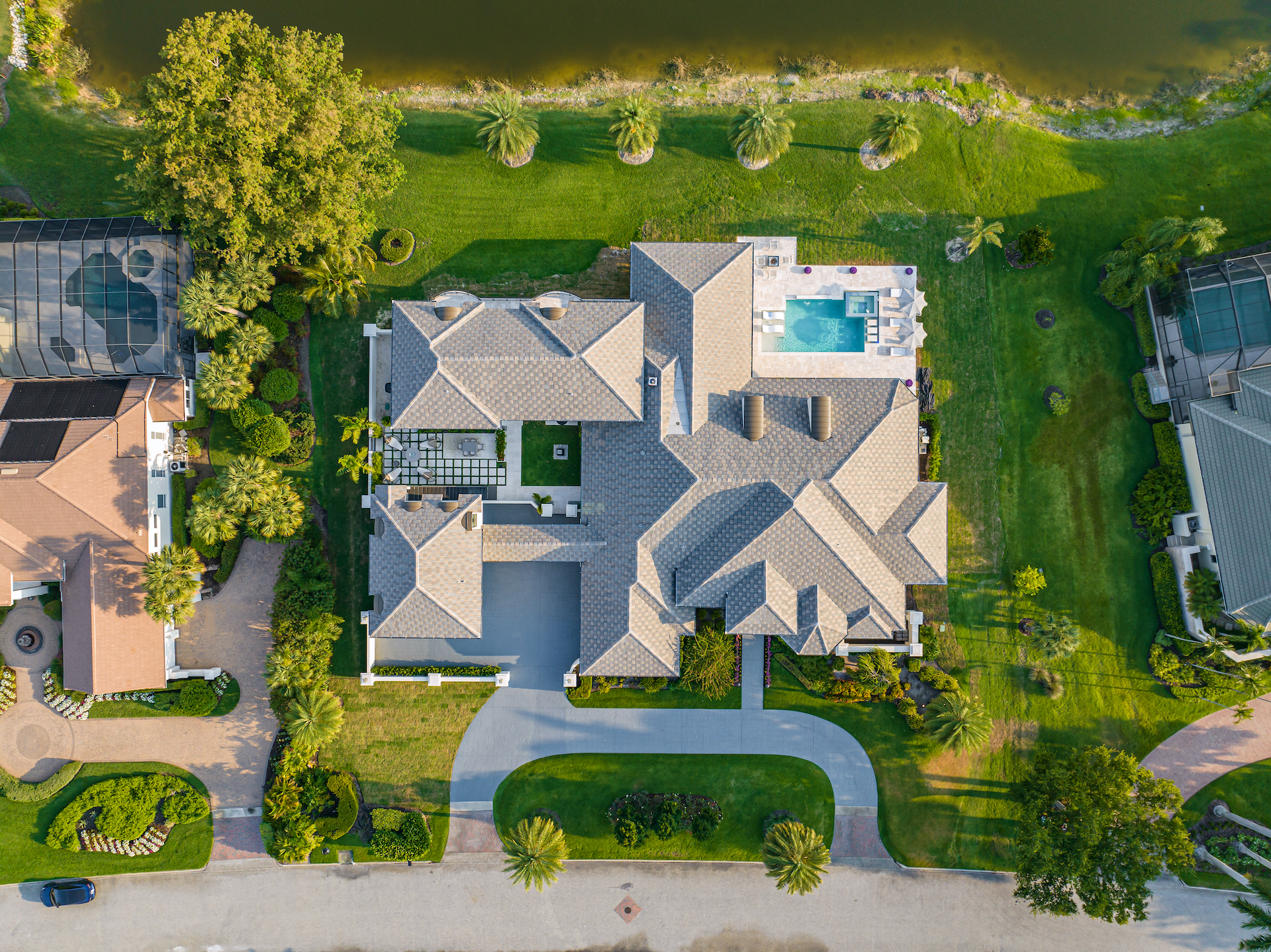 Aerial view of the Quail West luxury estate at 6536 Highcroft Drive, surrounded by a golf course and water views.