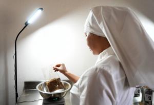 a sister (from behind) at a lab bench mixing mushroom coffee ingredients