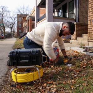 J. Blanton Plumbing technician providing plumbing maintenance services to a Chicago homeowner, ensuring proper sewer cleanout and clearing clogged drains to prevent costly post-winter plumbing issues.