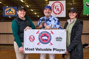 three people stand smiling holding a banner for most valuable player