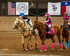 two polo players ride horseback