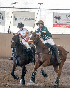 Two male polo players shoulder for a shot on the ball on horseback during polo game