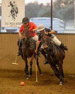 female polo player takes possession of ball in polo game