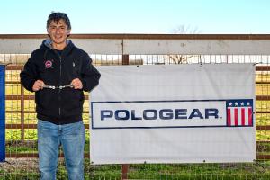 male polo player holds up trophy,smiling