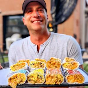 Man holding a plate of burritos