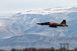 An F-5 Tiger II from the Saints of Fighter Squadron Composite (VFC) 13 takes off from a runway on Naval Air Station Fallon. The F-5 and other aircraft are used to pose as adversaries for U.S. Navy aircrews coming to TOPGUN.