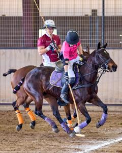 two arena polo players on horses one with the ball, one defending during U.S. Open Arena Polo Championship