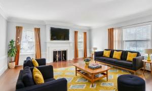 The open floorplan living room at 415 Ridge St., in Forest Hill Newark, features original herringbone hardwood floors, coffered ceilings and intricate moldings.