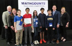 Four students, a math teacher and 4 TSPE representatives post in front of a "MATHCOUNTS Texas State Competition" sign.