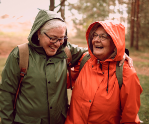 Smiling Older Adults Hiking in Raincoats