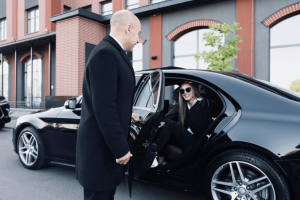 Luxury black car parked outside JFK Airport for a premium chauffeured experience.