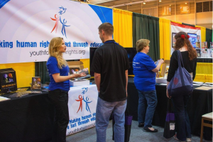 Erica Rodgers, National Director for Youth for Human Rights International (at left) showing the educational booklet to an educator at a teachers’ convention
