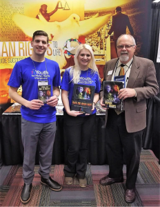 Youth for Human Rights representatives with the Mr. Terry Cherry, Past-President of the National Council for the Social Studies at the annual NCSS Convention showing the different human rights educational materials