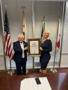 Hazel Ortega proudly holds the 2025 Woman of Achievement Award alongside California State Senator Bob Archuleta an honor granted for her outstanding contributions to community empowerment, education, and transformative altruism.