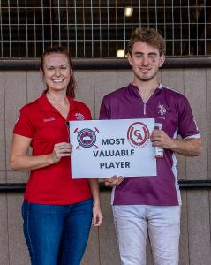 an arena polo plahyer stands with an insurance agent sponsor receiving his award
