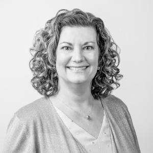 black and white headshot of a woman with curly hair