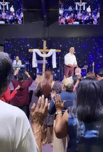 Dr. Norman Quintero stands before a congregation in worship at Gethsemane Fellowship Church, symbolizing the faith-based foundation behind the new inpatient rehabilitation center launched in partnership with Path of Light Counseling.