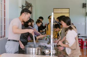 Founder Alan Phung volunteering at the Vi Nhan Children's Disability Care Center in Buon Ma Thuot, Vietnam, serving food to the students in the cafeteria.