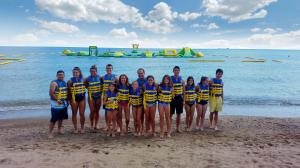 Group standing in front of the floating Aqua Park at WhoaZone at Whihala Beach