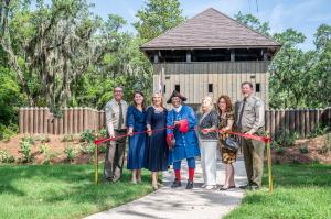 From left, Robert Yero, Julia Gill Woodward, Kathleen Brennan, Charles Ellis, Dr. Kathleen Deagan, Dr. Jane Landers and Chuck Hatcher cut the red ribbon to signify the opening of the 1738 fort reconstruction at Fort Mose Historic State Park in St. Augustine, Florida.
