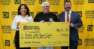 Photo of a large donation check held up by two men and one woman