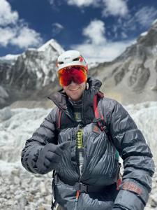 Andrew Ushakov stands in front of Everest