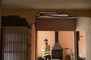 A restoration expert inspects structural damage inside a property to assess repair needs.