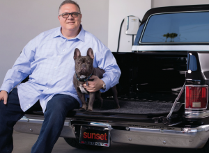 Phil Mitchell sits with his pet French Bulldog