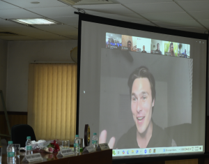 A man - Sam Brooks, BD Manager of Stashlete, seen on a white screen delivering a speech virtually from USA during DDA's BallPark Inauguration event in India
