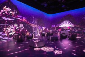 ♿ Image Alt Text (for Accessibility & SEO): Interior view of Illuminarium Las Vegas featuring a 360° immersive digital projection with ambient lounge seating, set to host Bitcoin Illuminated.