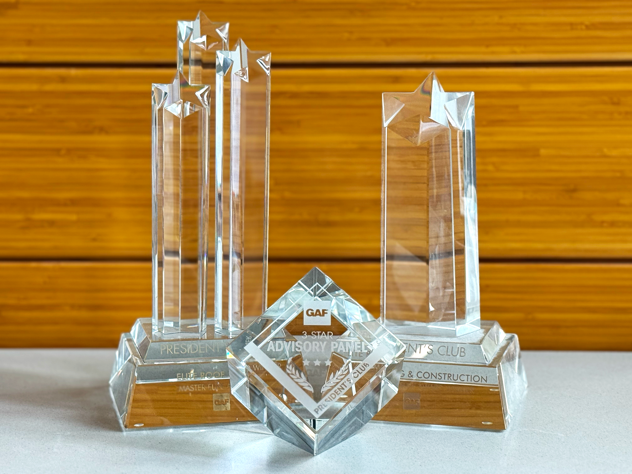 GAF President’s Club Award for Elite Roof and Solar, featuring a crystal trophy with three star-topped pillars, symbolizing top-tier roofing excellence and recognition in the solar and roofing industry.